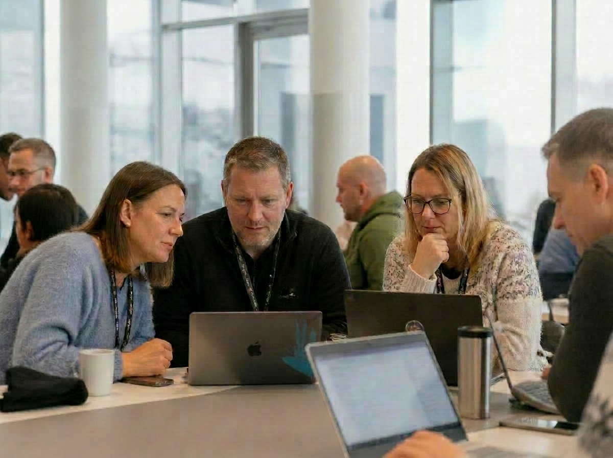 Deltakere som jobber sammen på hackathon, med Firn-rollup i bakgrunnen